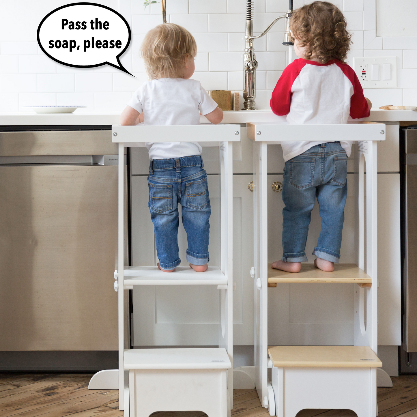 Two children are standing at the kitchen sink.  Both are in Explore N Store Learning Towers.  One child says "Pass the soap".