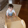 A young boy is climbing up the ramp side of the 2-in-1 Folding Learn N Slide.