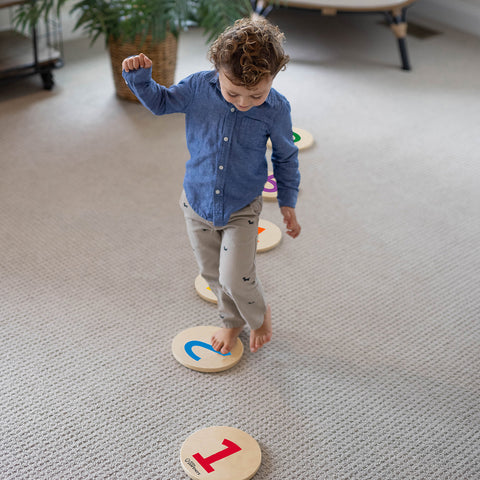 A young boy is walking on the Numbers Stepping Stones.