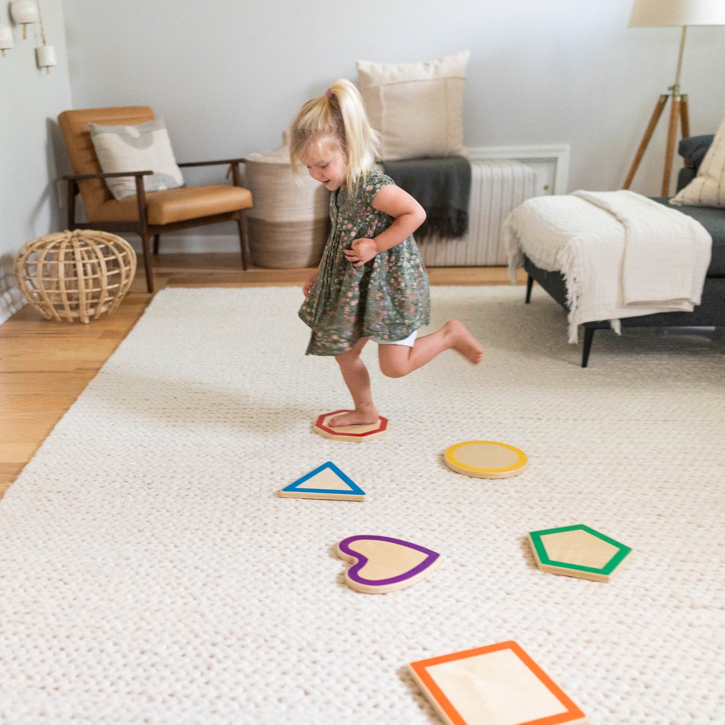 A young girl is walking on the Shape Stepping Stones.