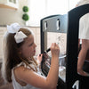 A young girl is drawing on the included plexiglass panel.