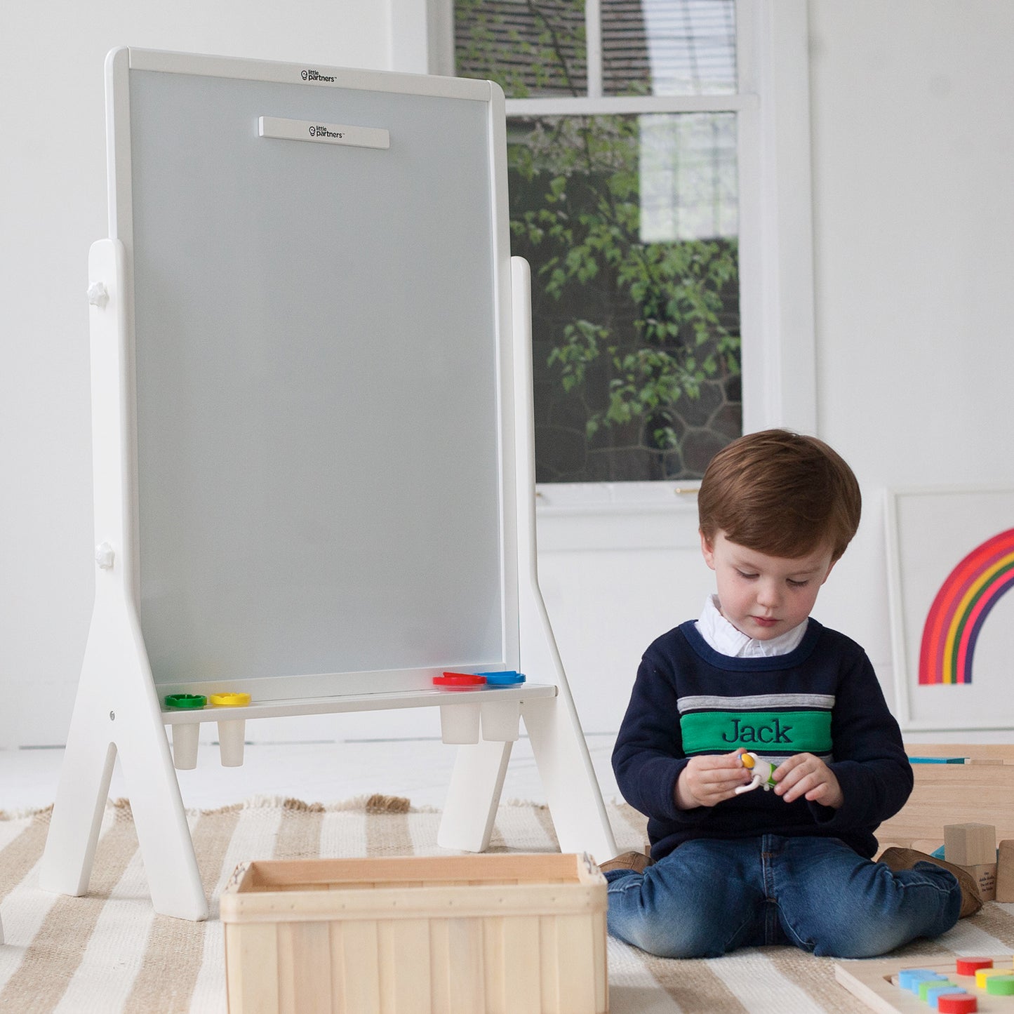 A boy is sitting next to the Contempo Art Easel.