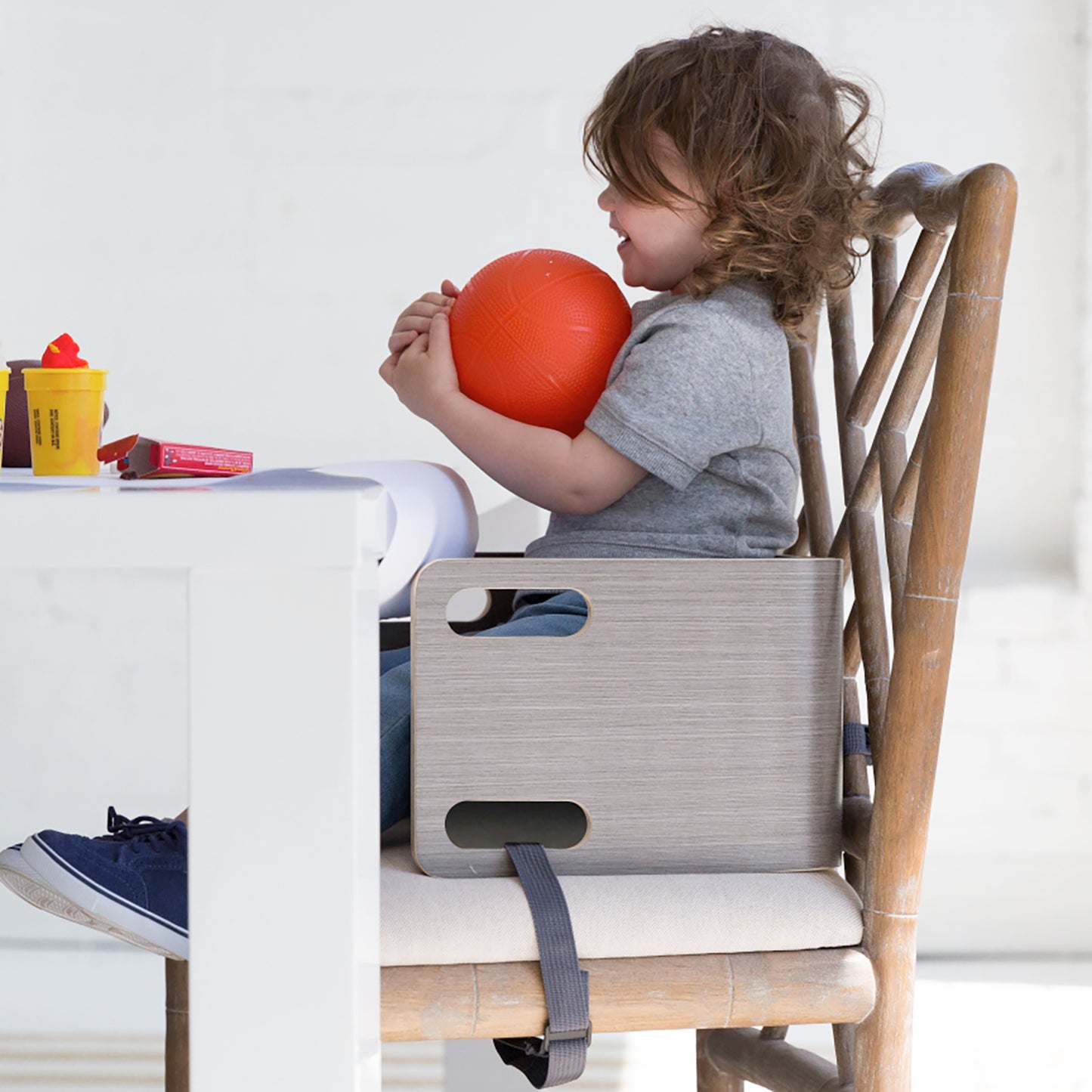 A young boy sits at the table in the 3-in-1 Learning Booster and Step Stool.