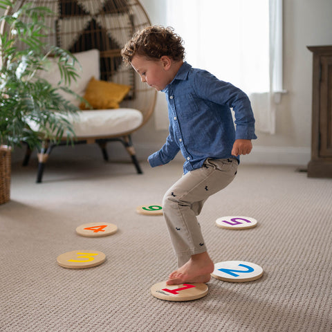 A young boy is walking on the Numbers Stepping Stones.