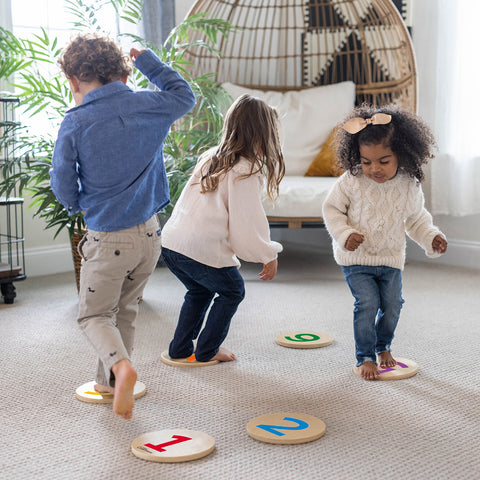 A young boy and two young girls are walking on the Number Stepping Stones.