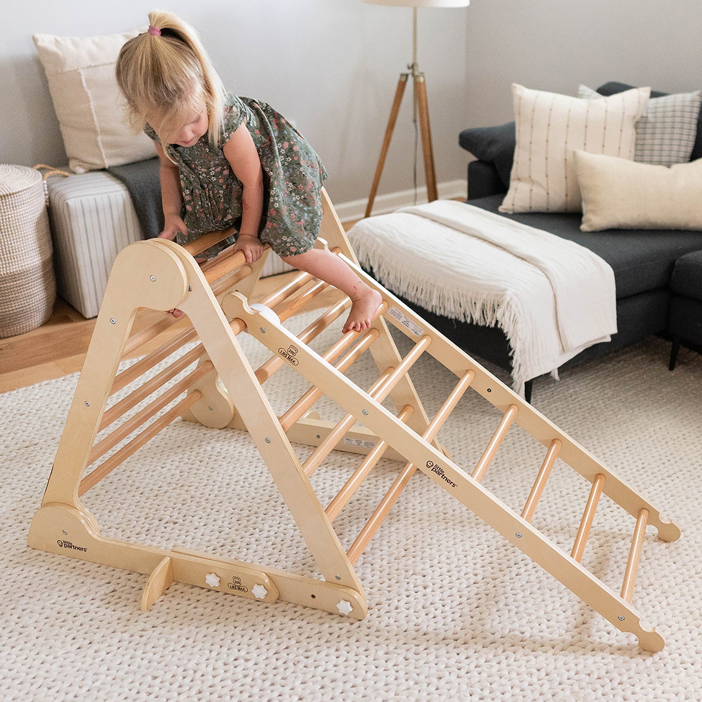 A girl is climbing on the Climbing Ladder, which is attached to the Climbing Triangle.